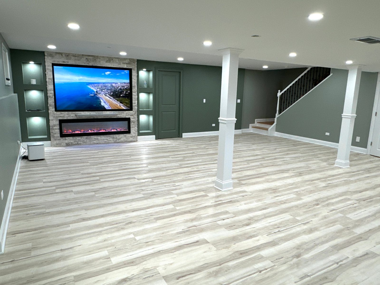 Bronze basement: open finished room with drywall ceiling, recessed lights and wood-look flooring