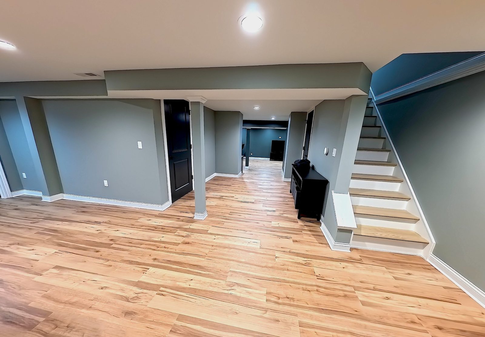 Basement hallway and stairs with wood-look flooring