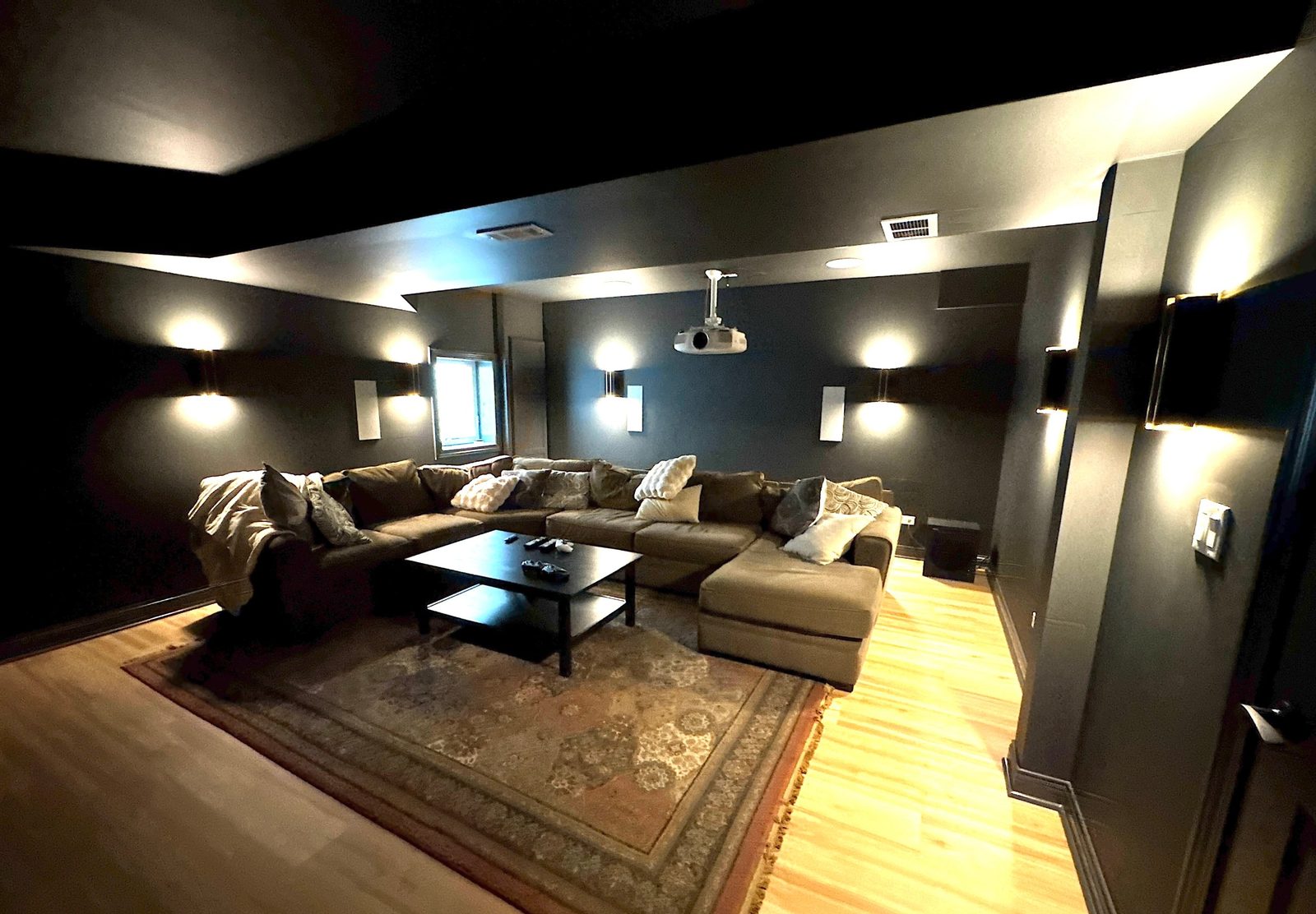 Basement theater room with sectional and projector