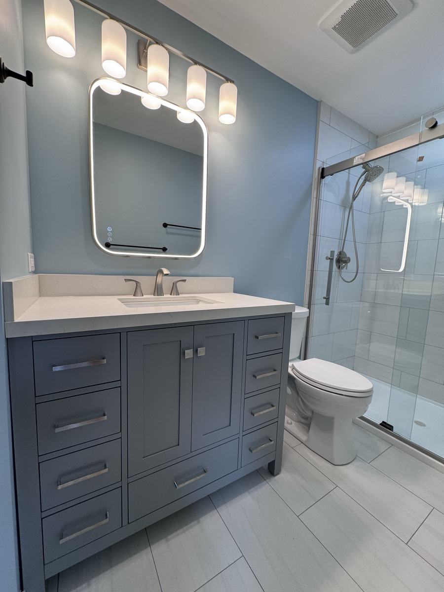 Bathroom vanity with mirror and glass shower