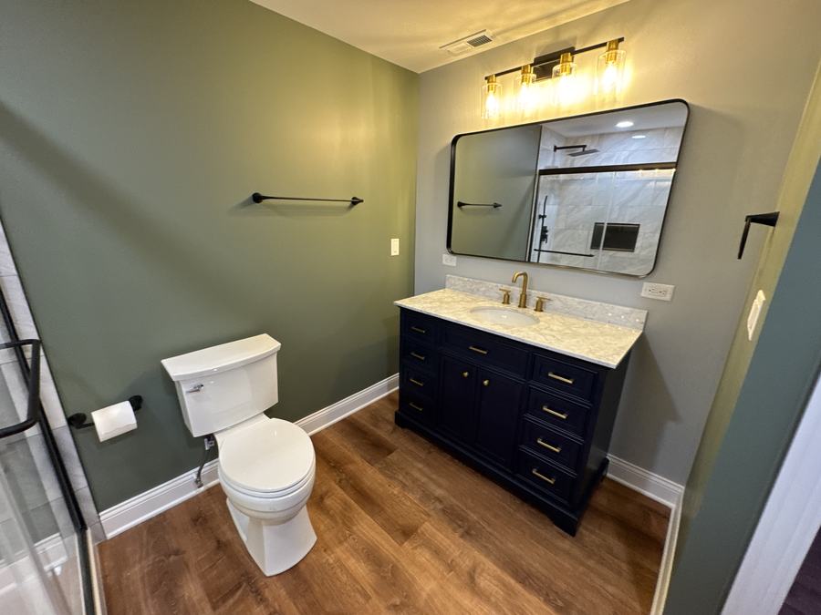 Bathroom with navy vanity and gold fixtures
