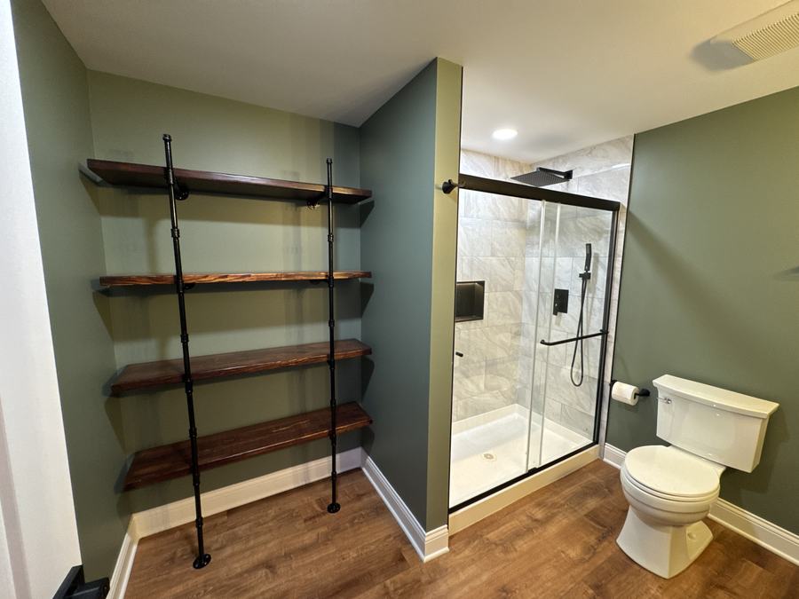Bathroom with open wood shelving and glass shower