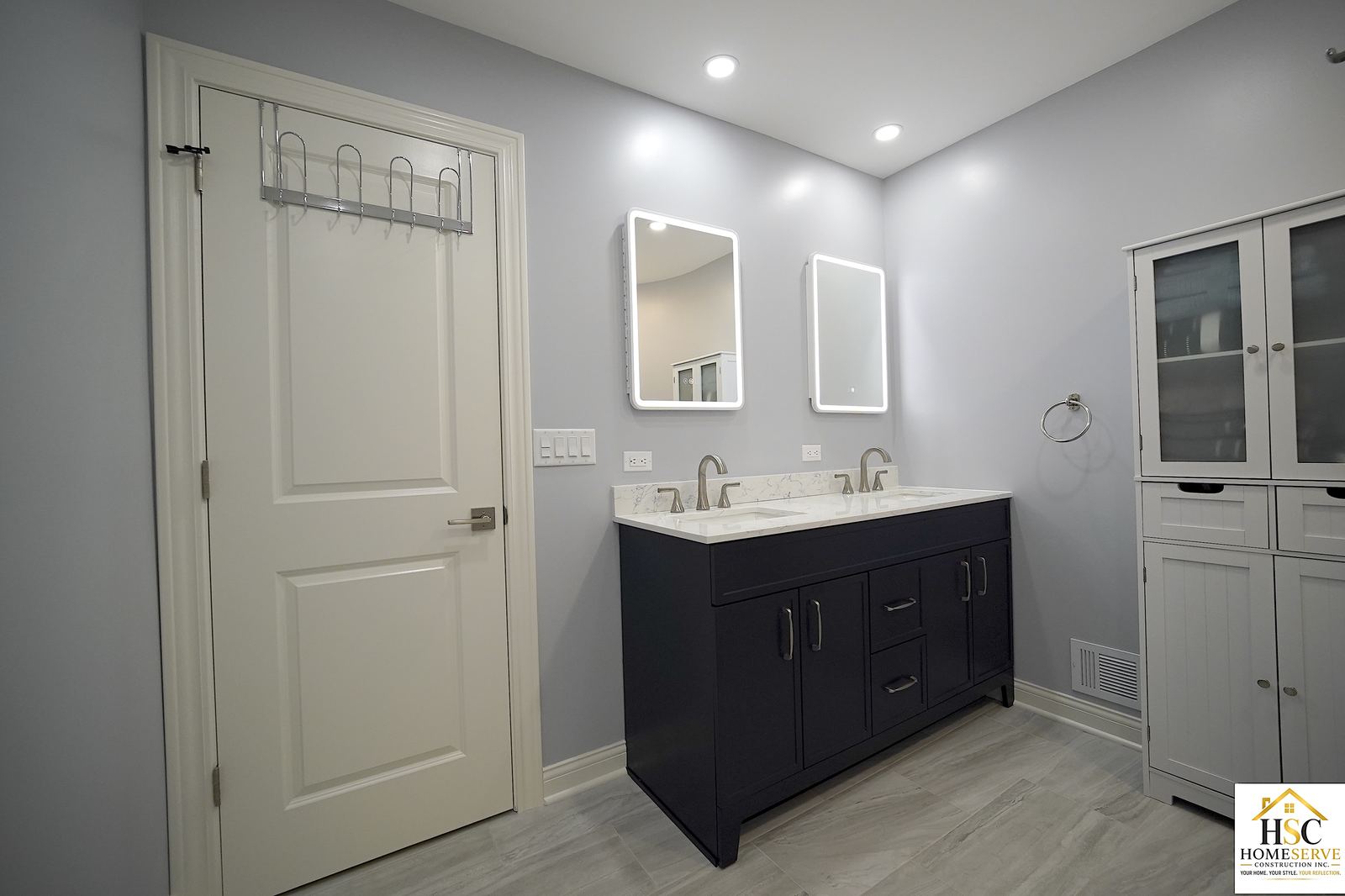 Gurnee bathroom after: navy double vanity with backlit mirrors