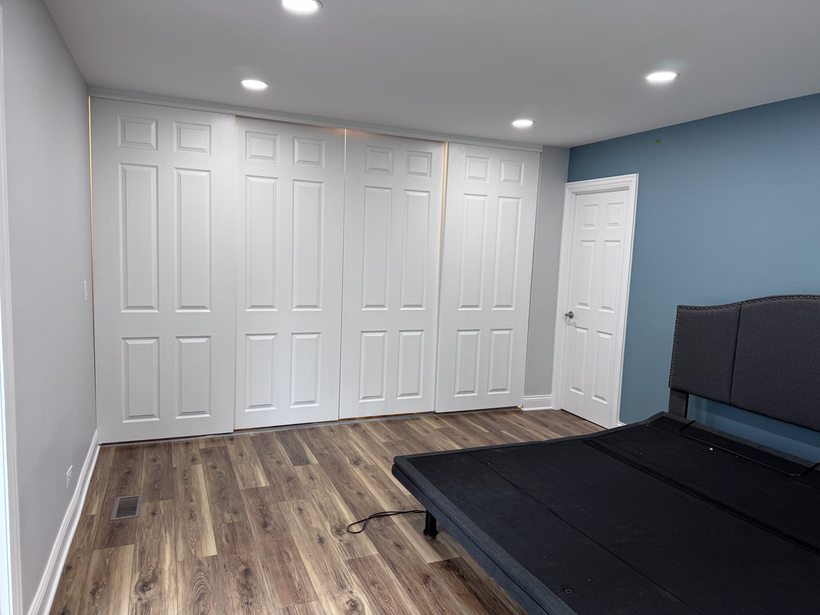 Finished Hanover Park bedroom with white closet doors and a blue accent wall