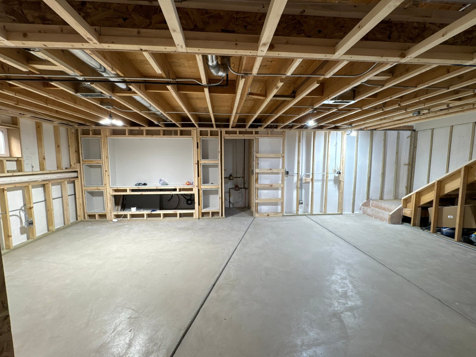 Basement before the remodel: framed walls and bare concrete floor