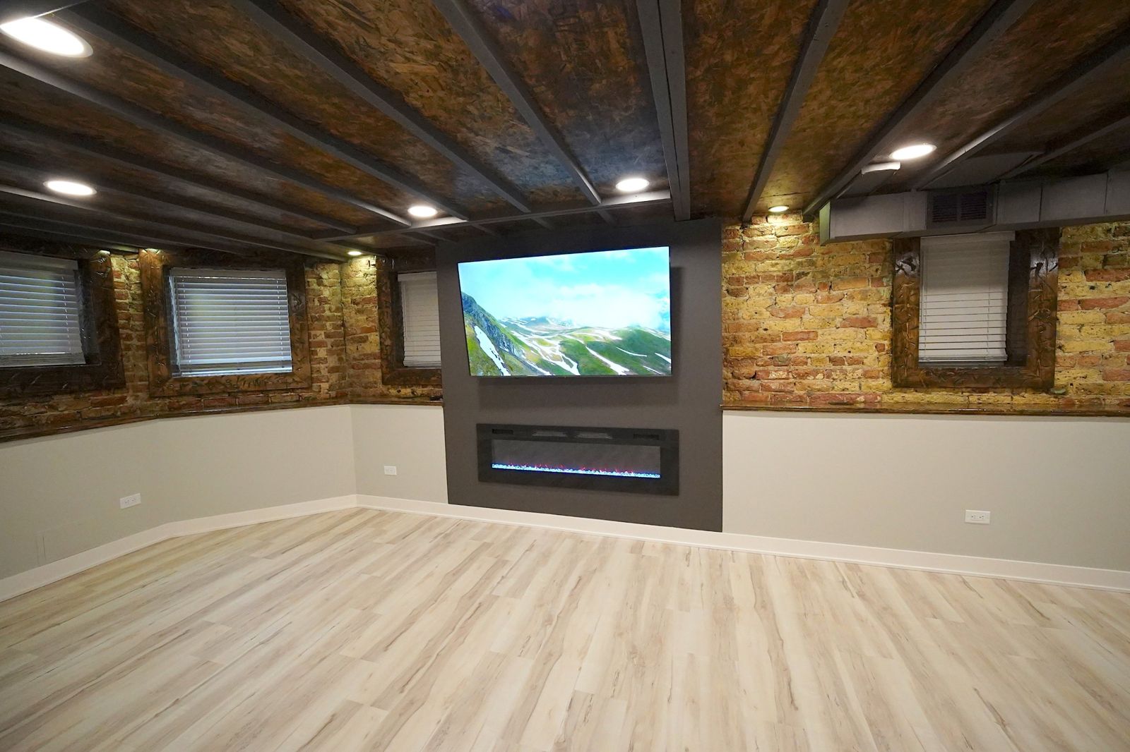 Finished basement with brick walls, TV and fireplace
