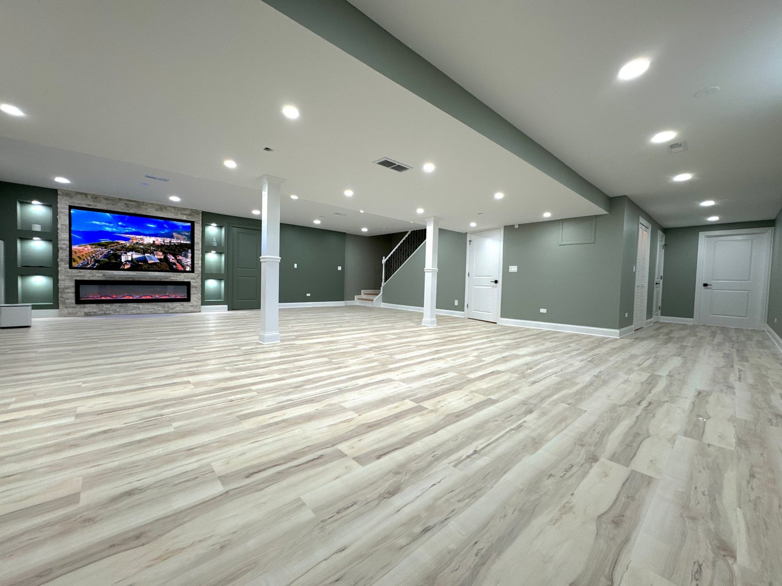 Finished basement with open layout and stone fireplace wall