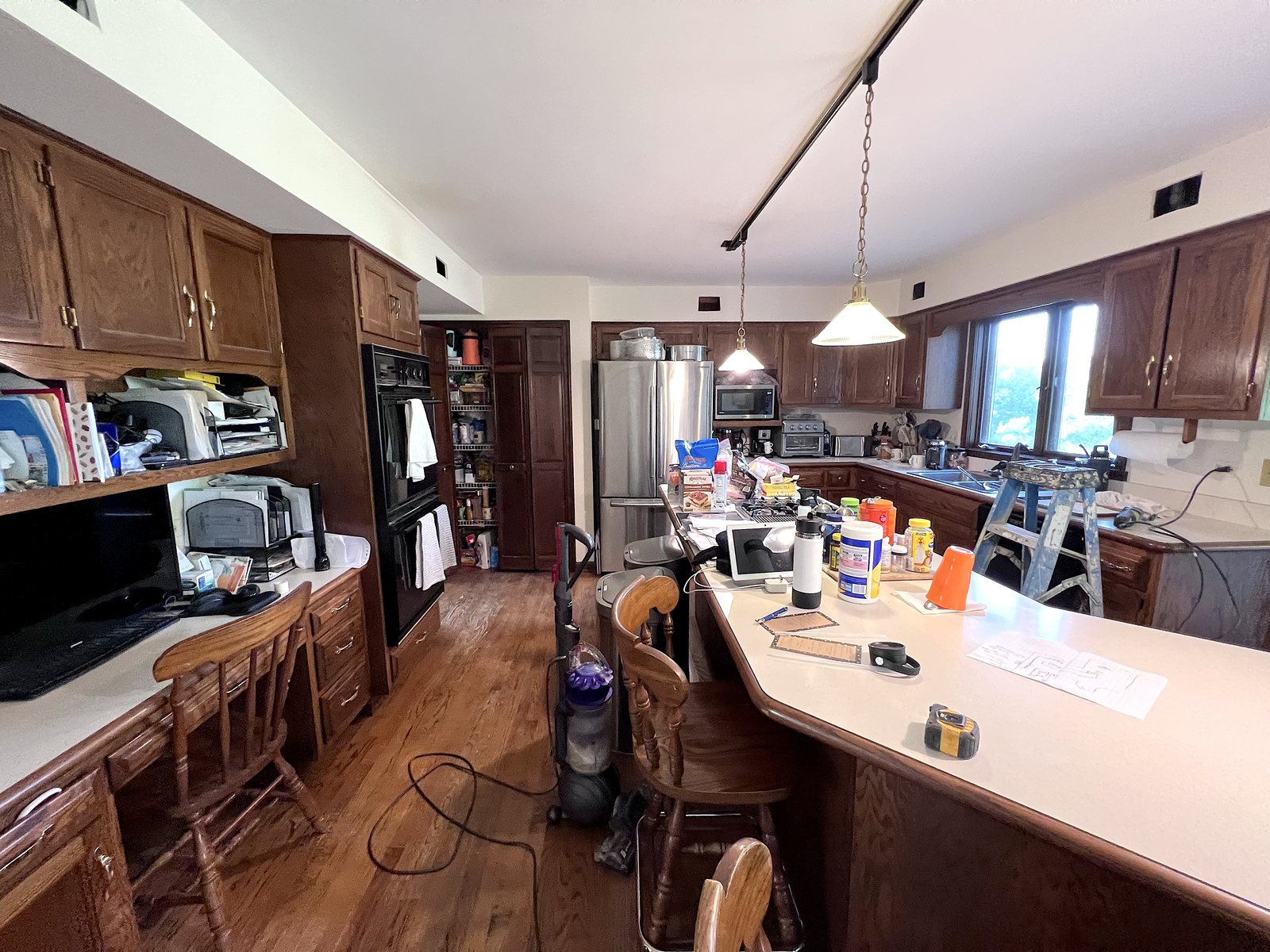 Kitchen before the remodel: dark oak cabinets, cream counters and track lighting
