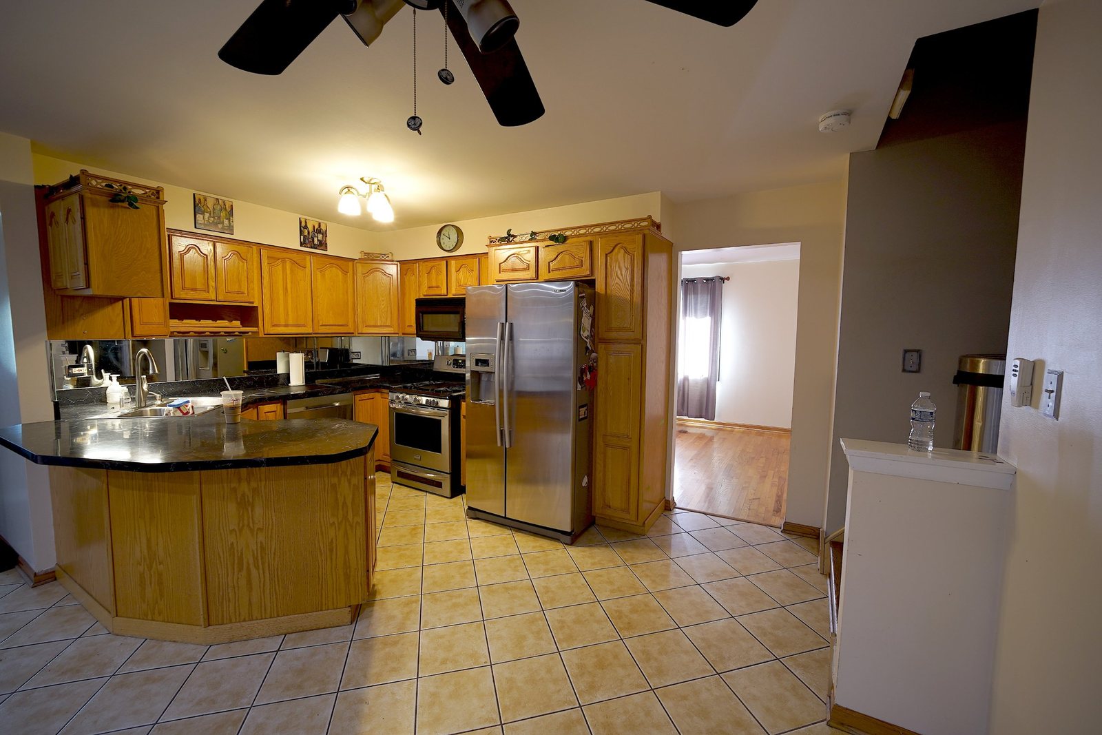 Kitchen before the remodel: oak cabinets, dark counters and tile floor