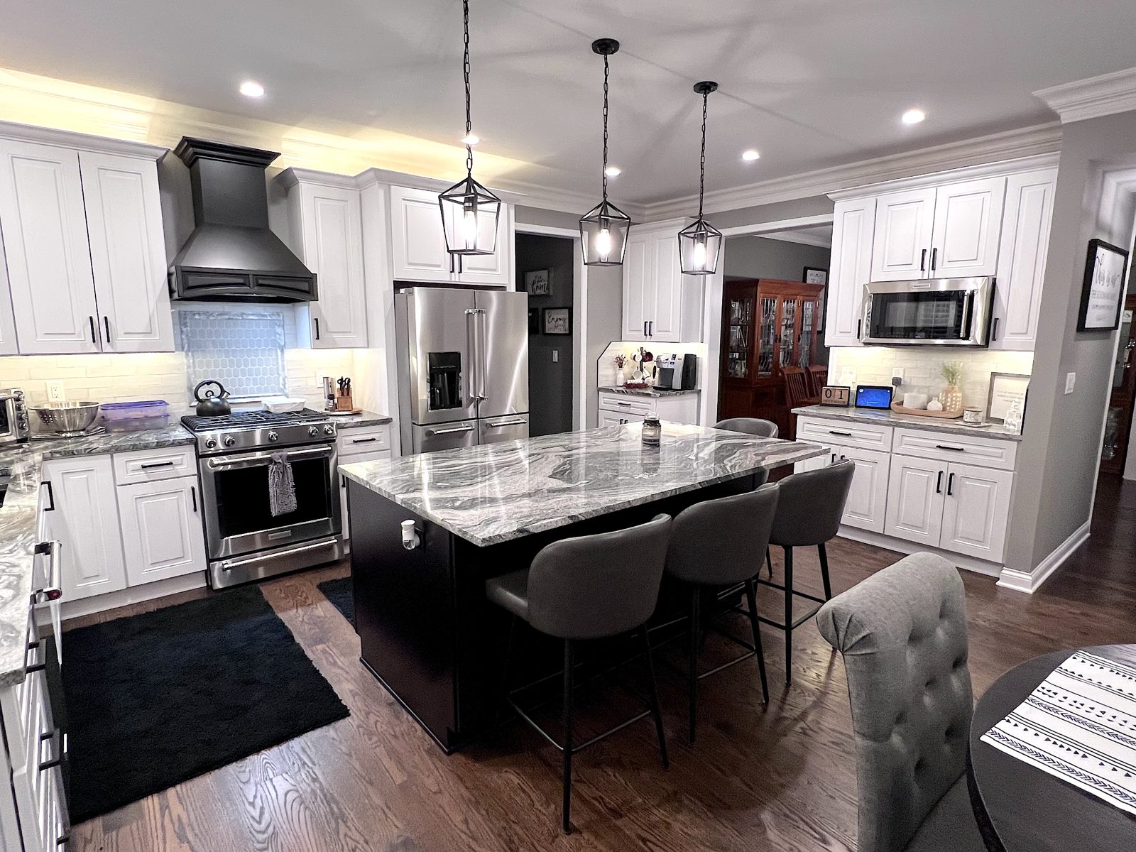 Gold kitchen: white cabinets, granite island with seating and pendant lights