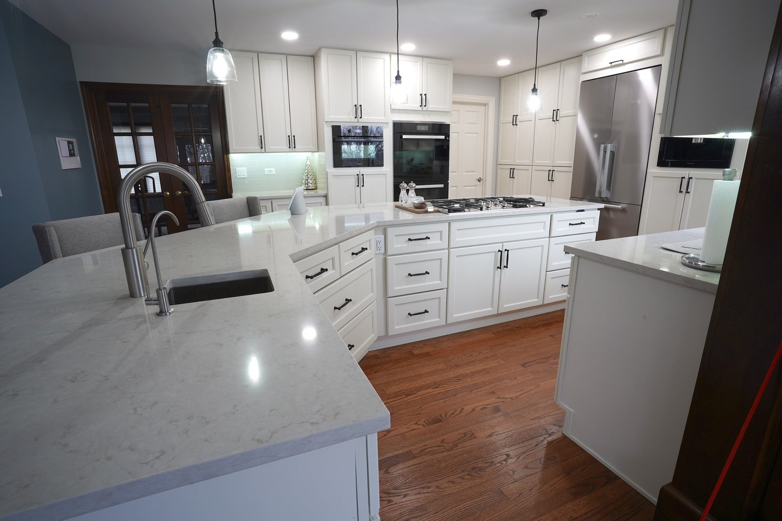 White kitchen with quartz island and double wall oven