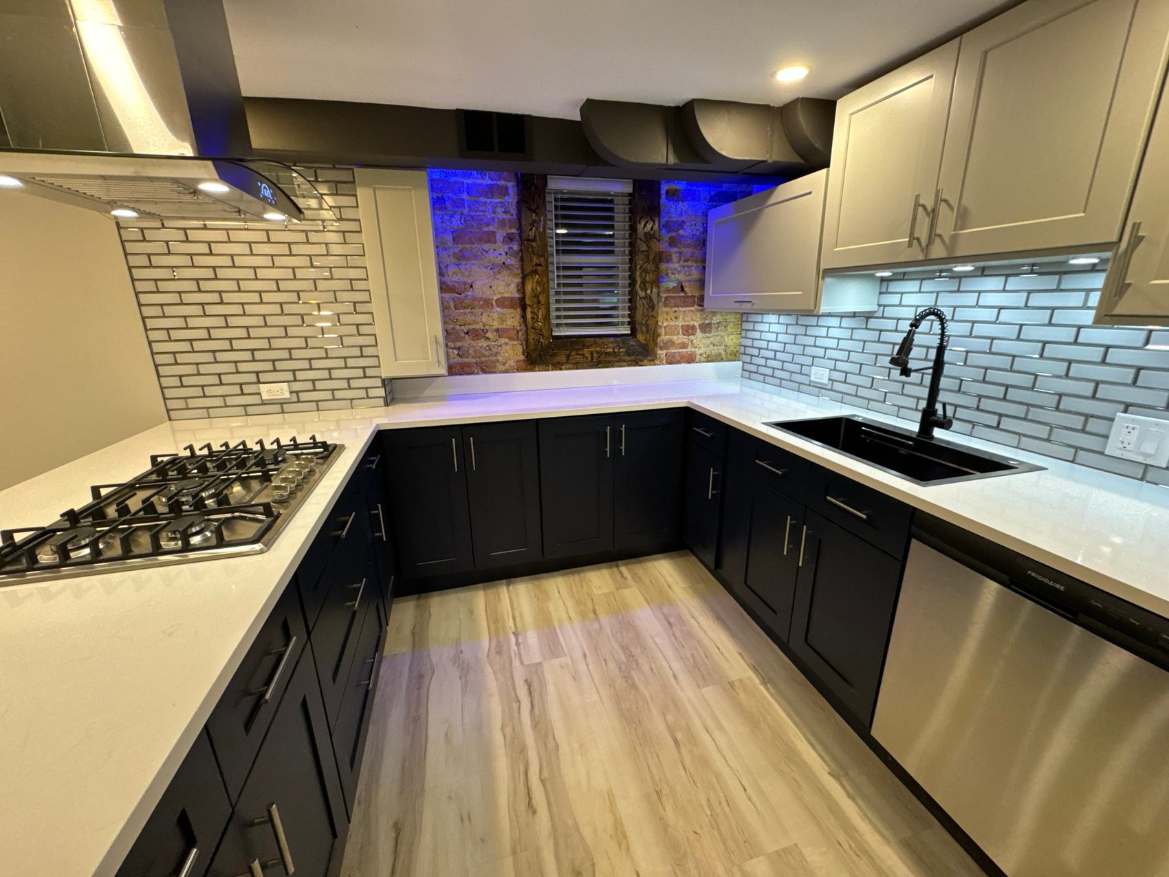 Navy base cabinets against exposed brick
