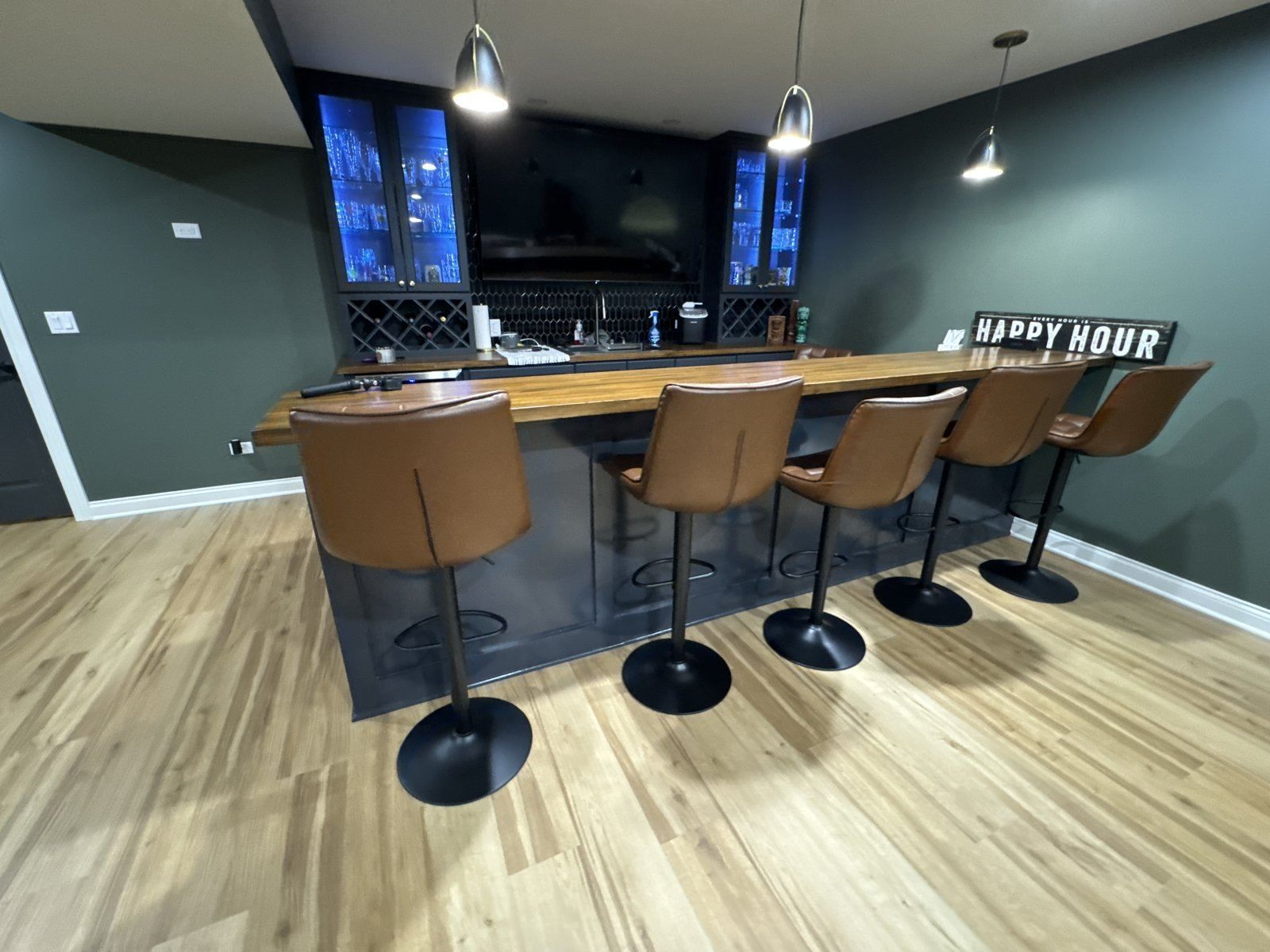 Finished basement bar with wooden counter and bar stools
