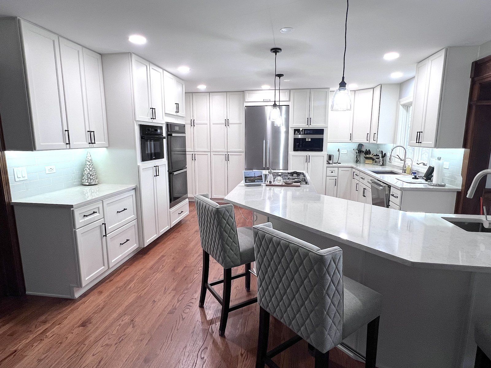 Kitchen island with upholstered bar stools and quartz counter